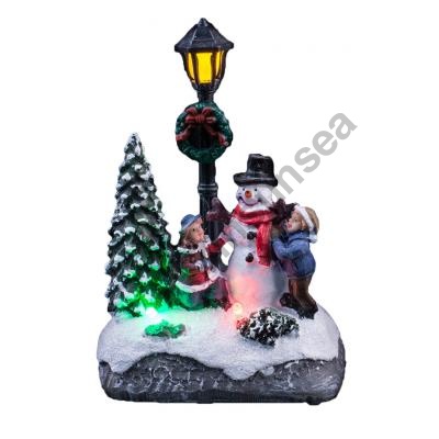 Iluminado escena de Navidad con niños decore el muñeco de nieve